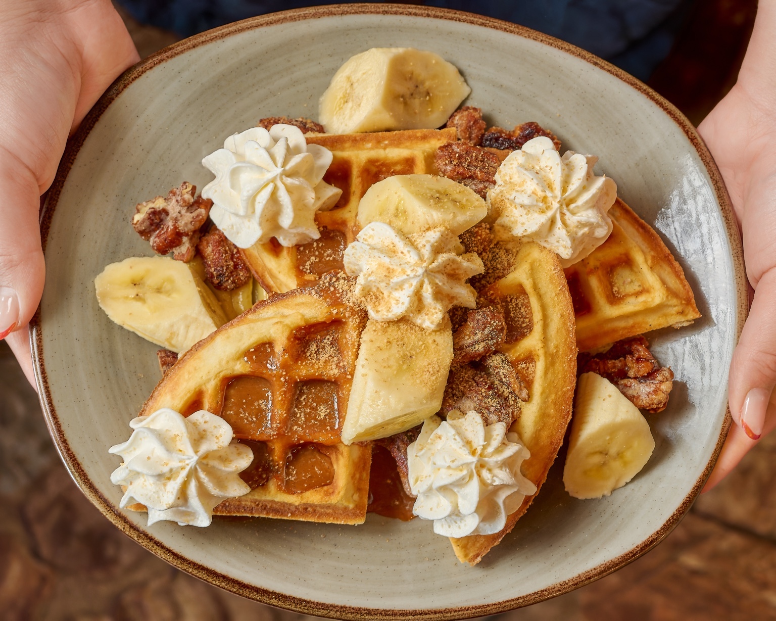 Plato de waffles sostenido por unas manos